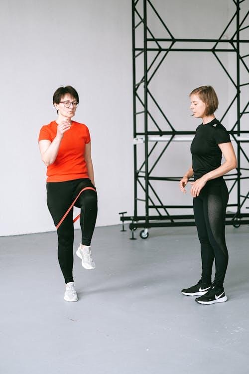 Woman exercising with resistance band and trainer indoors