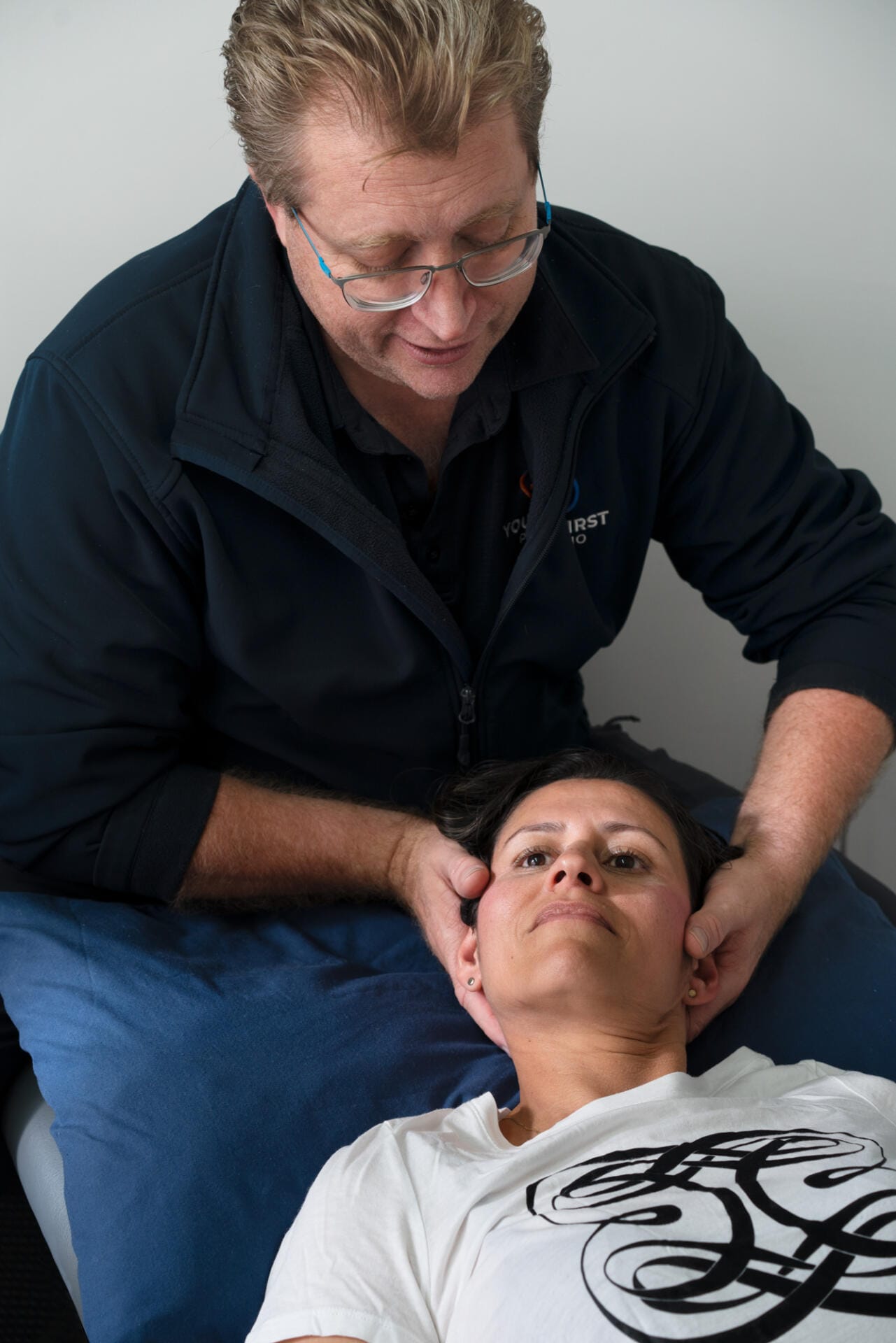 Chiropractor performing neck adjustment on female patient