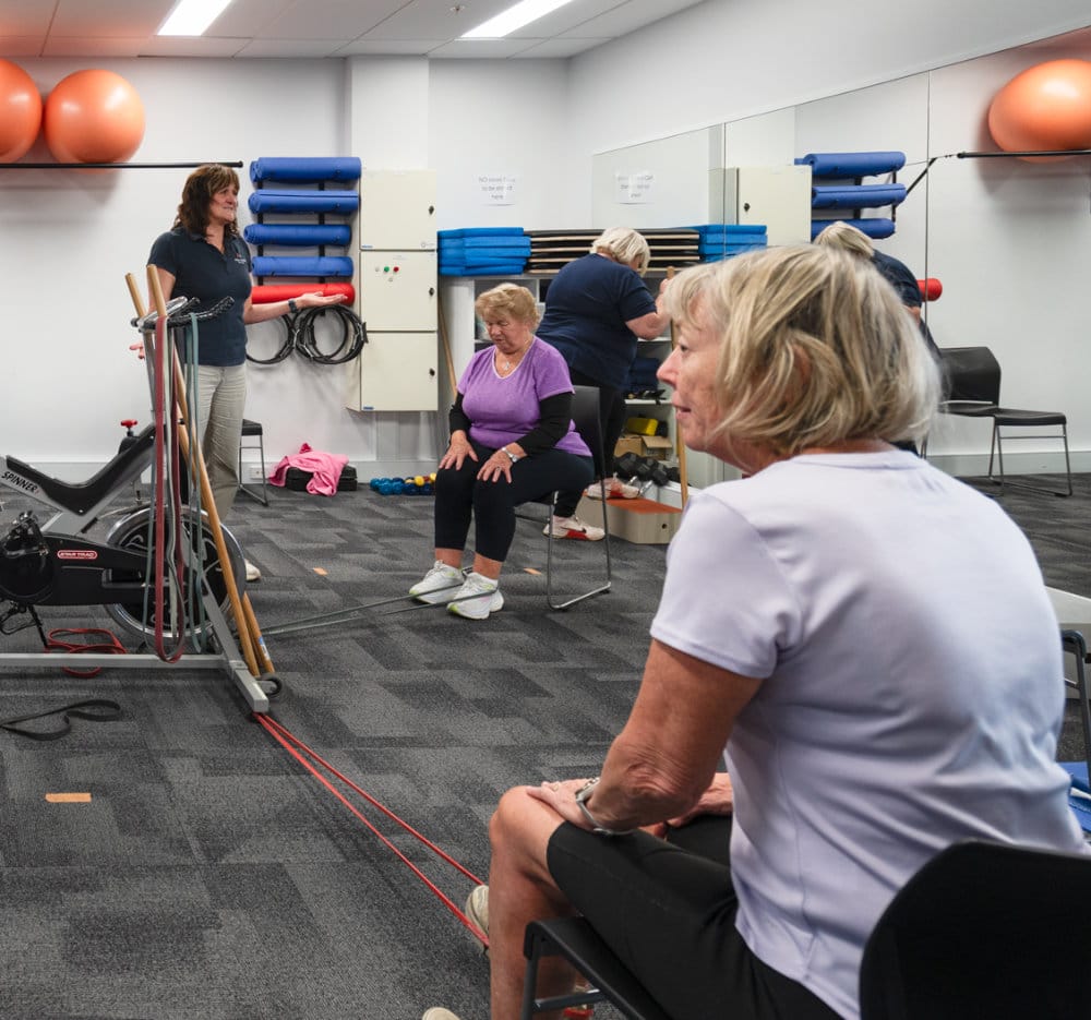 Older women doing seated exercise indoors