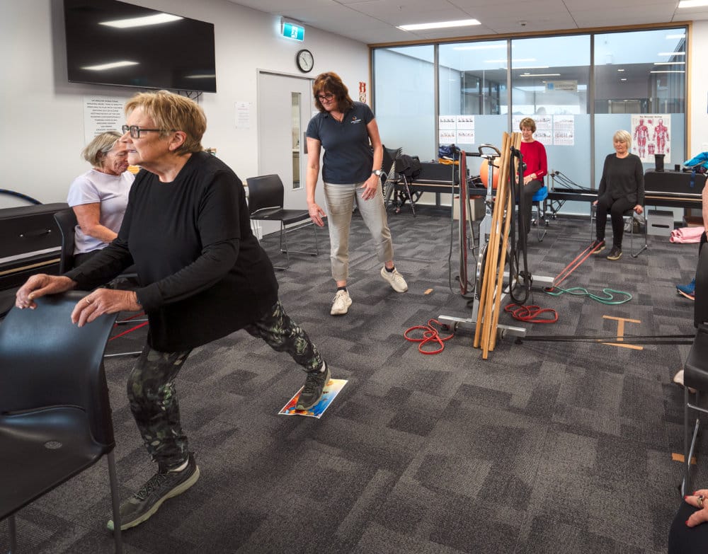 Older adults exercising in physiotherapy with instructor